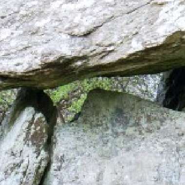 Large rocks precariously balanced, with moss adding a touch of greenery to the rugged stone surfaces of Gaulstown Dolmen.